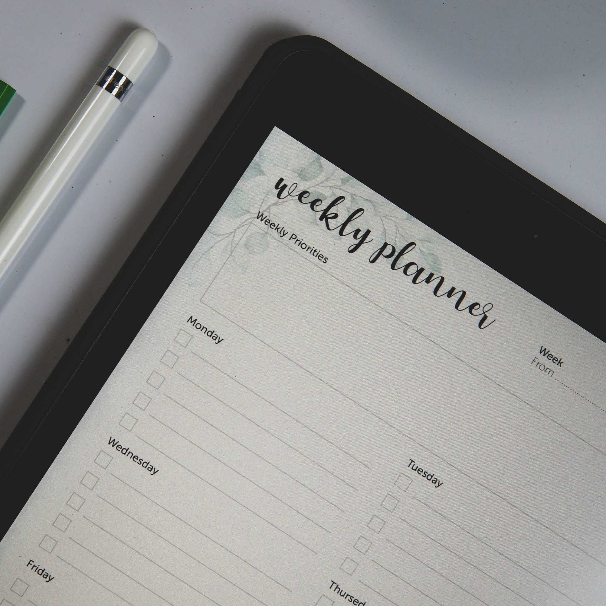 Digital tablet with planner layout and stylus on a desk